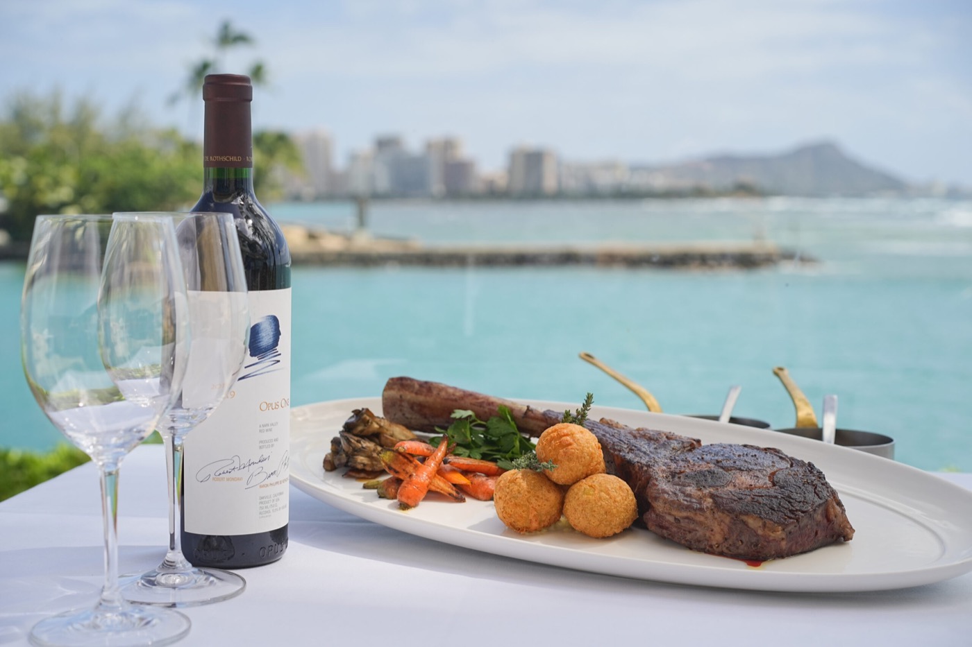 Floor-to-ceiling oceanfront dining room at 53 By the Sea with views of Diamond Head and Waikiki.